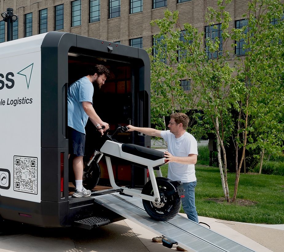 Crew unloading equipment from an electric work van ramp