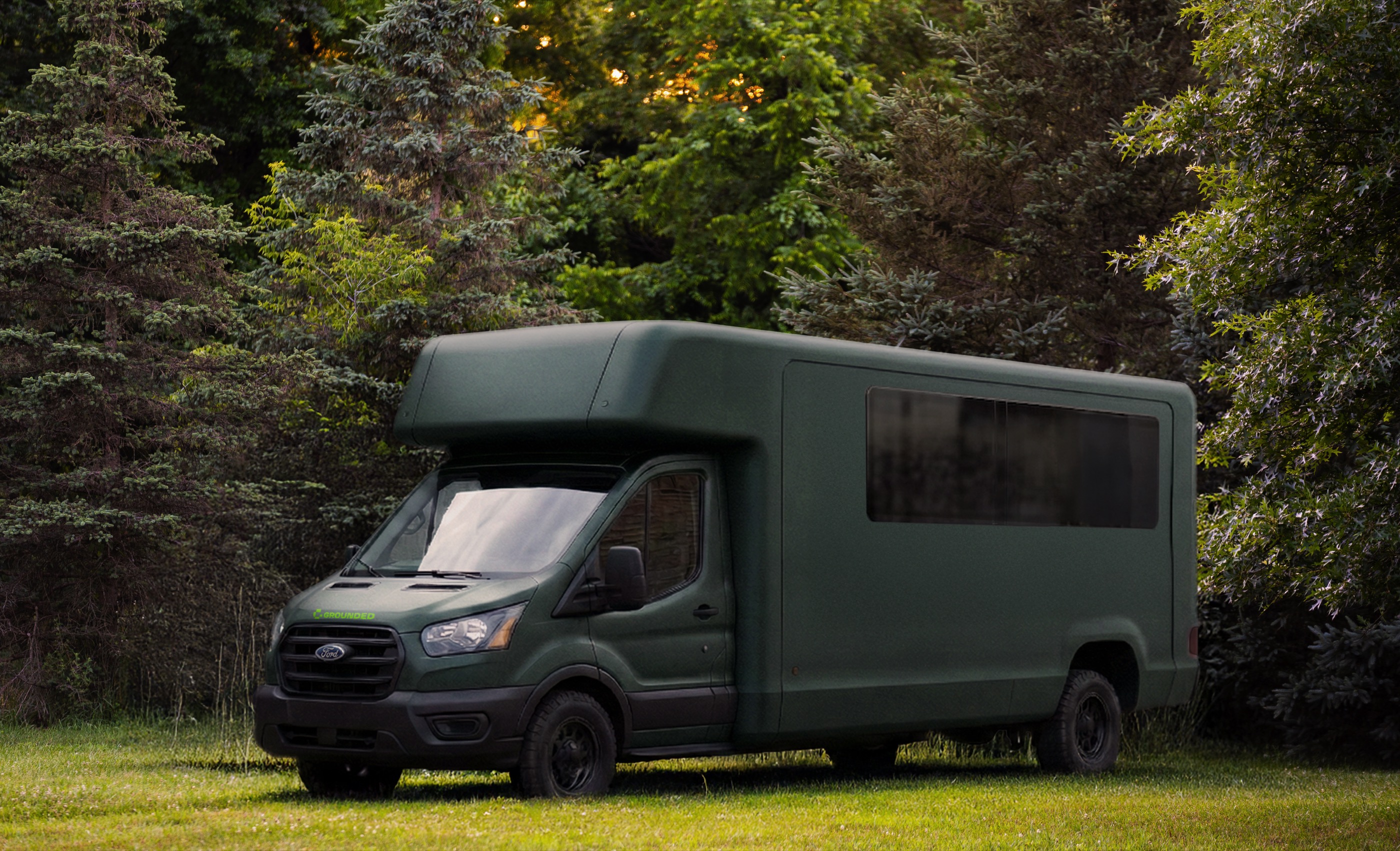 Grounded RV on the Ford Transit chassis parked among green trees